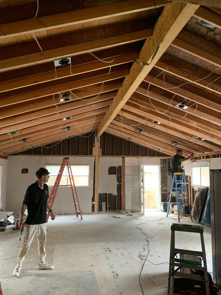 Home interior stripped to the studs with vaulted ceiling framing and new recessed lighting during a Los Angeles home renovation by Build & Beyond Remodeling